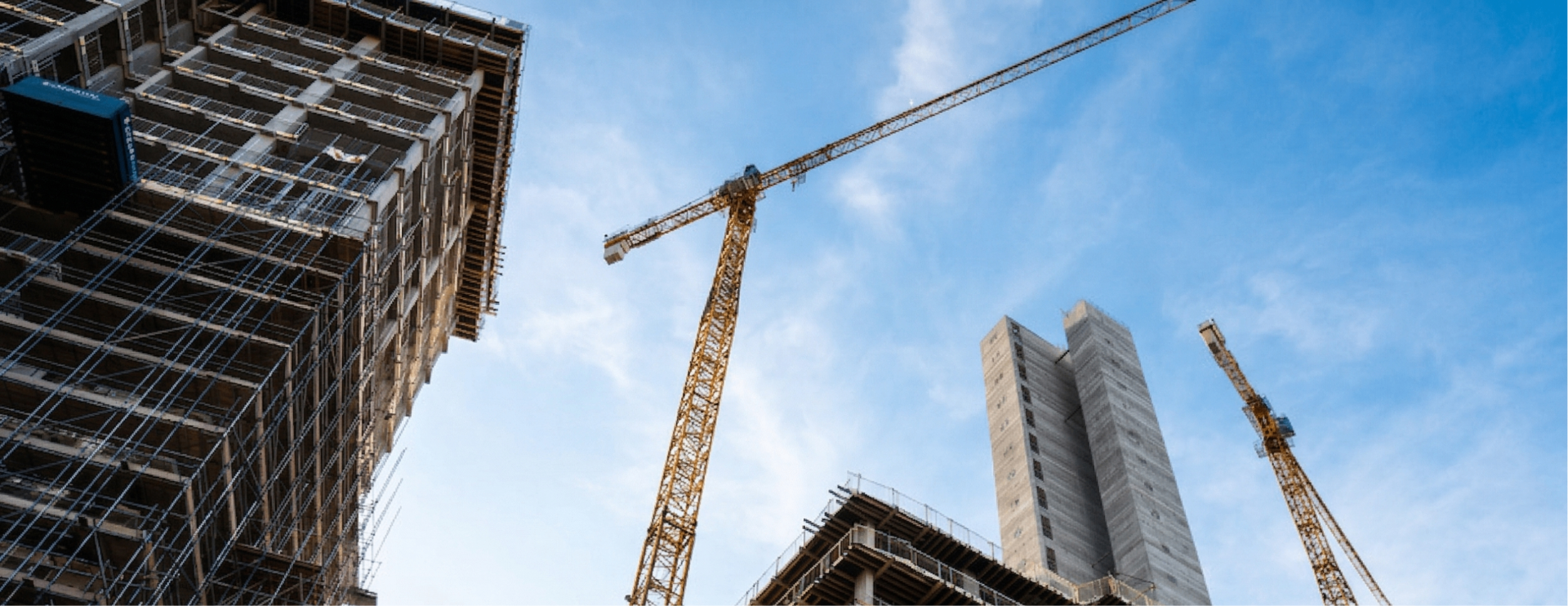 Construction site with cranes and high-rise buildings under a blue sky